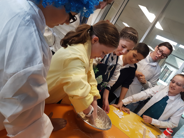 Gemma mixing ingredients to create bread at the Rise Up station