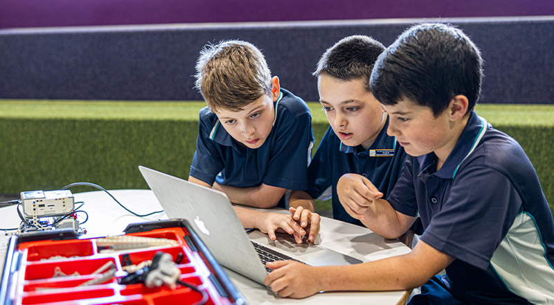 Students sitting around the laptop at Our Lady of the Angels Primary School Rouse Hill