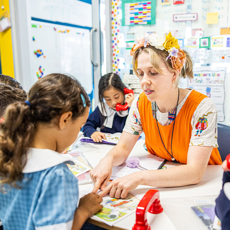 Student learning to read with his teacher at Our Lady of the Angels Primary School Rouse Hill