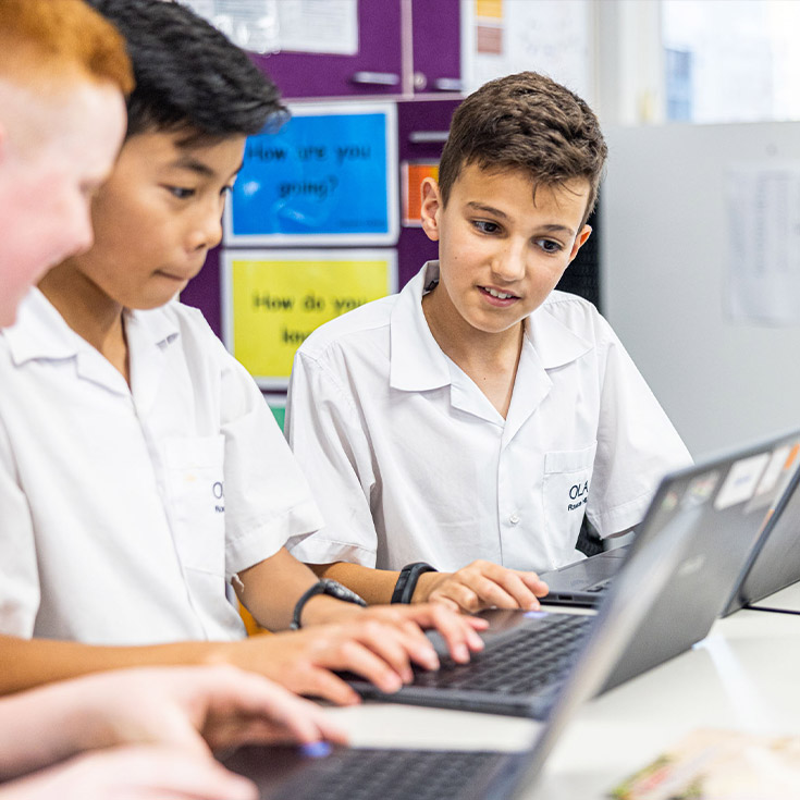 Students sitting around the laptop at Our Lady of the Angels Primary School Rouse Hill